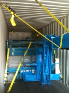 Boom lifts anf scissor lifts strapped inside container