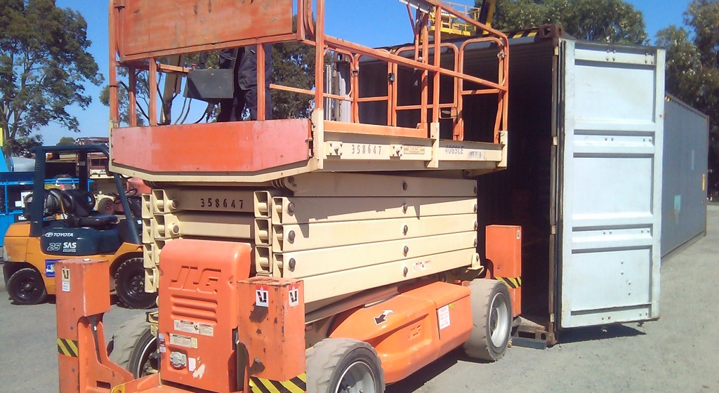 JLG 4069 scissor lift being loaded in container